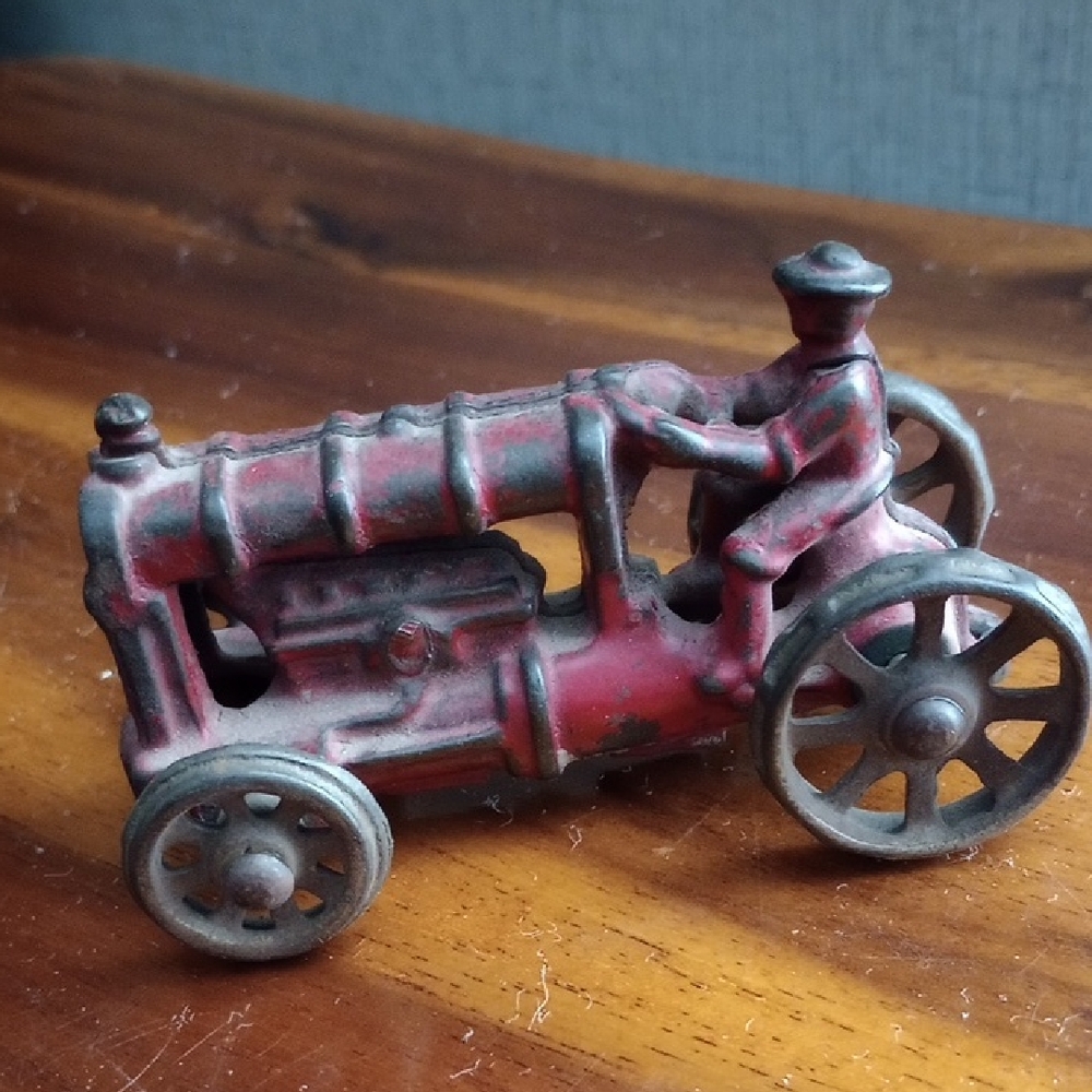 Vintage Red Cast Iron Fordson Toy Tractor with a Built-in Driver Figure.